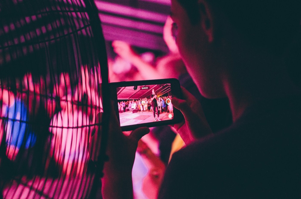 An attendee recording an event on a phone